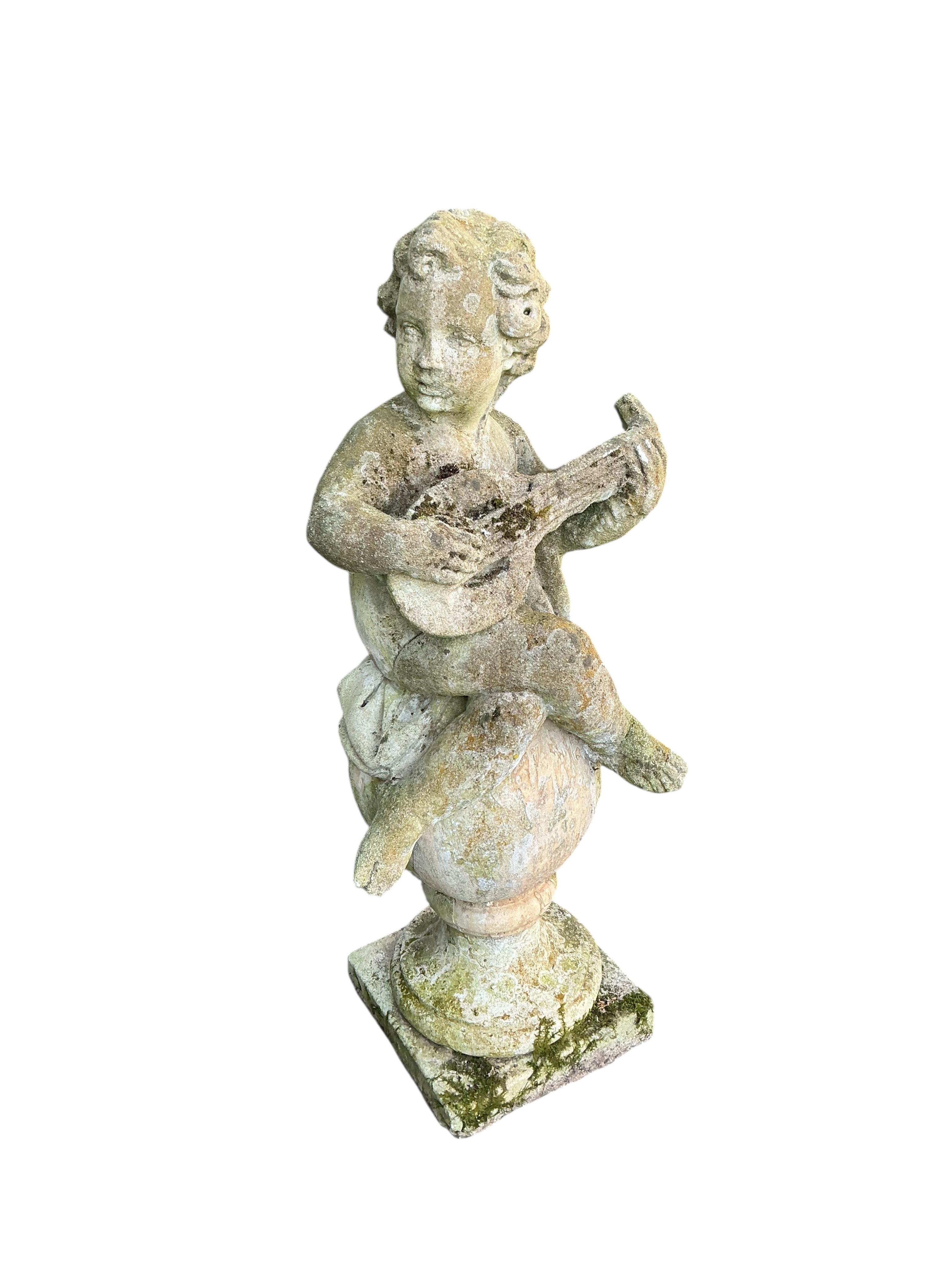 A reconstituted stone musical cherub garden ornament, height 100cm